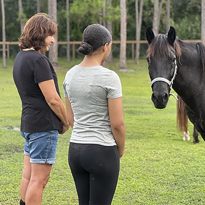 Two women looking at horse