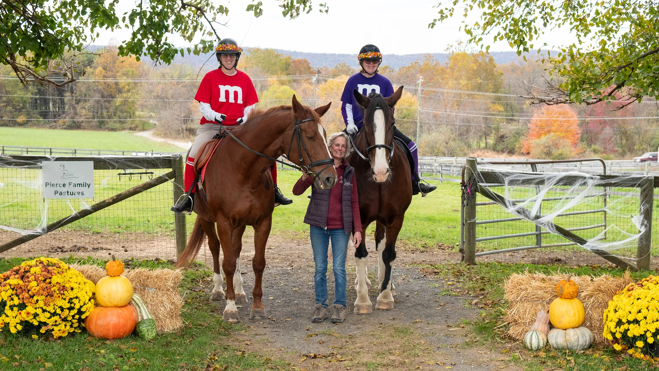 Two riders in M&M costumes with instructor at Ride-a-Thon